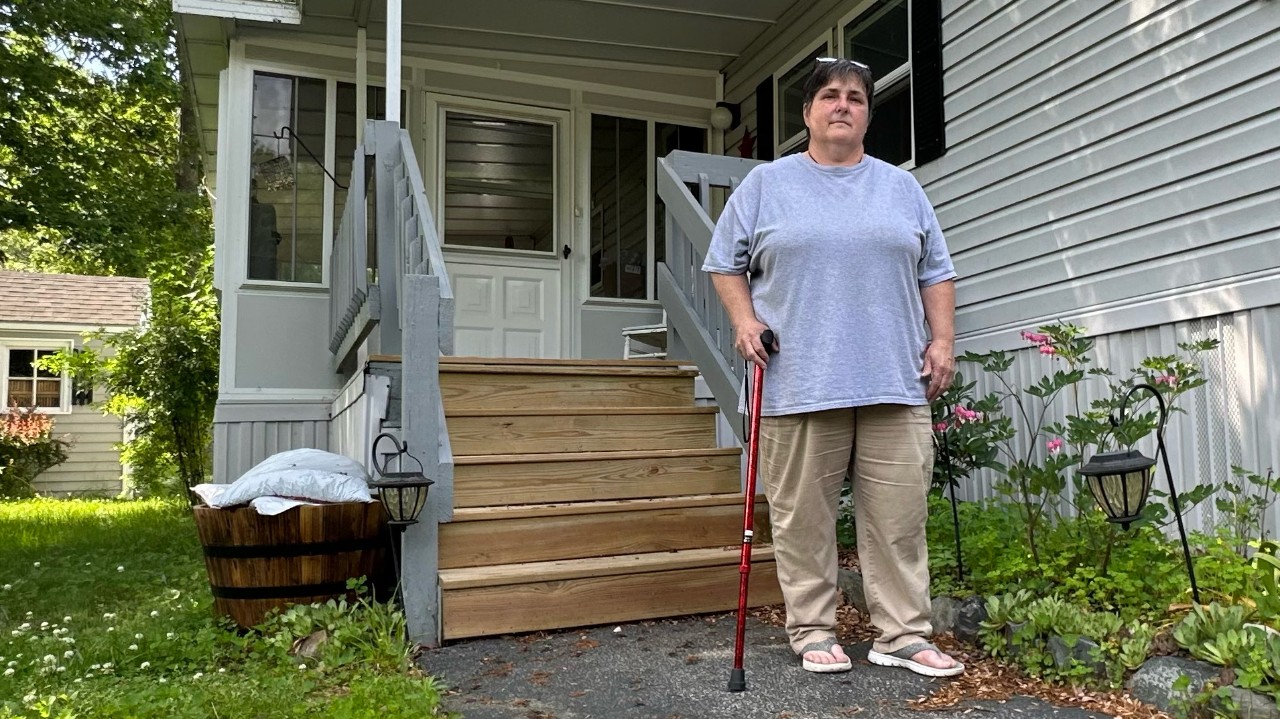 Jennifer Moreau stands in front of her home on Shady Lane in Shady Oaks Mobile Home Park in Arundel Friday. A new town ordinance limits how much and how often her rents can now go up. (Spectrum News/Sean Murphy)